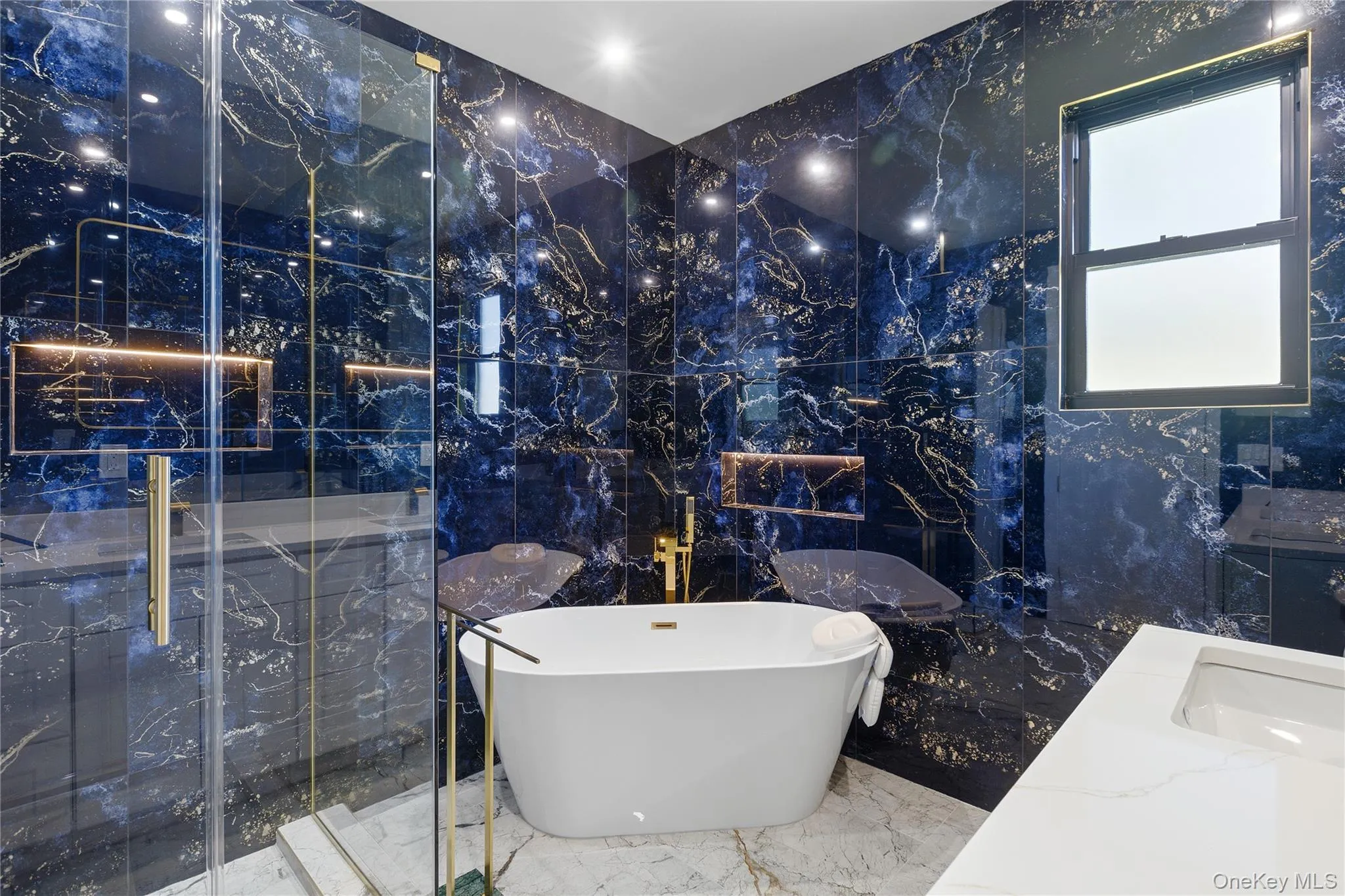 Freestanding soaking tub with gold-finish fixtures Freestanding soaking tub with gold-finish fixtures
