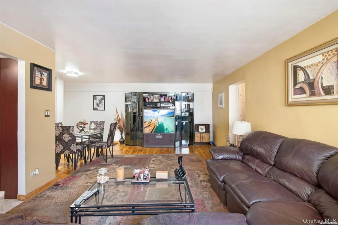 Open-concept living area with wood-finish flooring, a dedicated dining space, and overhead lighting Open-concept living area with wood-finish flooring, a dedicated dining space, and overhead lighting