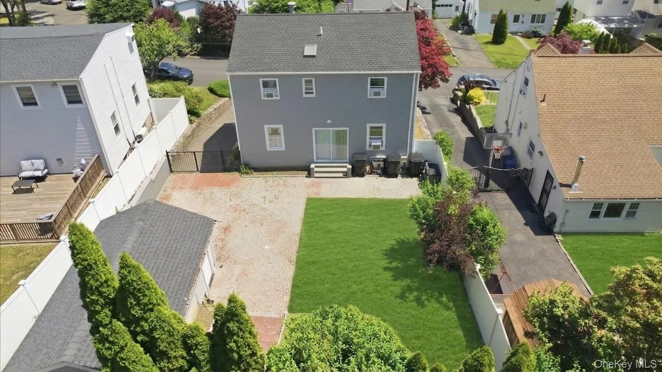 Expansive backyard featuring a manicured lawn area, brick-paved patio, and mature landscaping Expansive backyard featuring a manicured lawn area, brick-paved patio, and mature landscaping