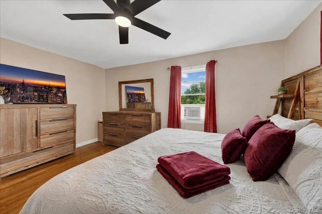 Primary bedroom featuring hardwood-style flooring extends across this room, featuring a built-in ceiling fan with light fixture Primary bedroom featuring hardwood-style flooring extends across this room, featuring a built-in ceiling fan with light fixture