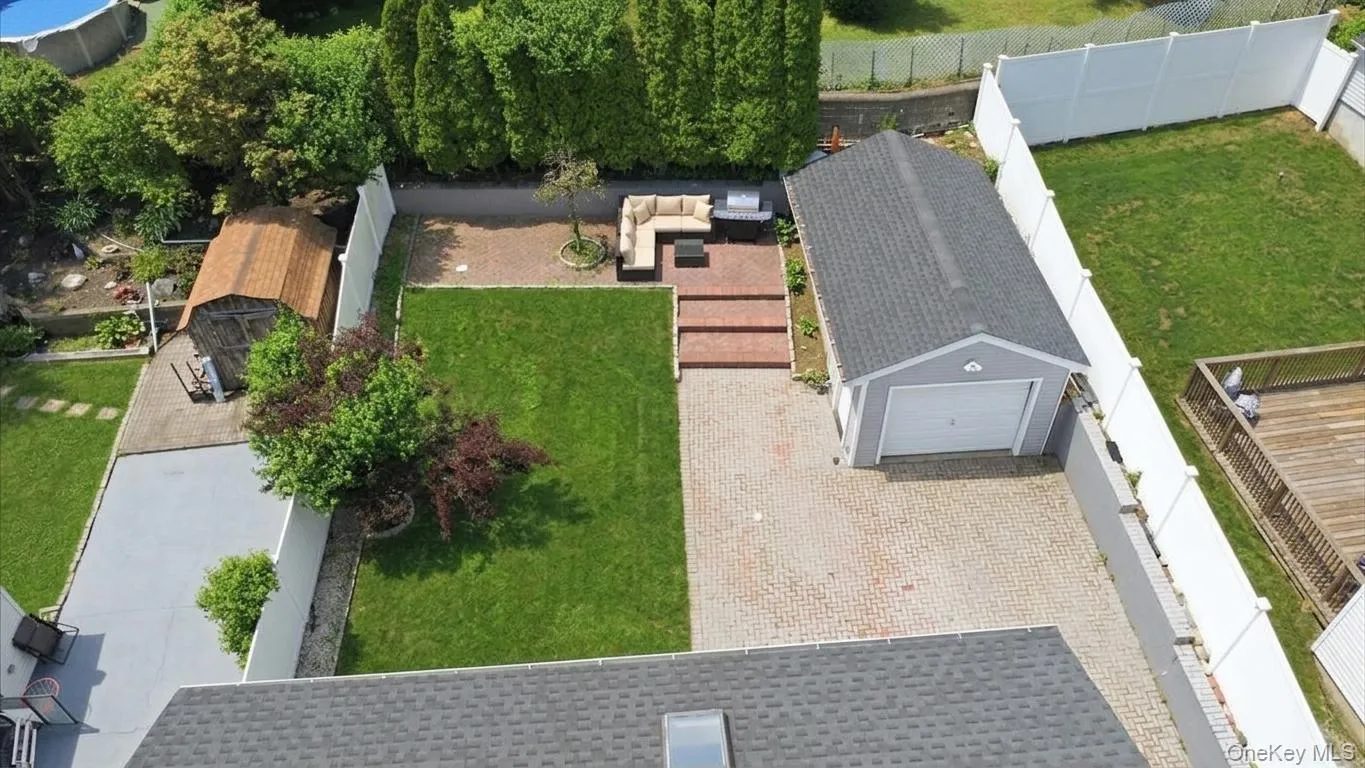 Detached garage with a white overhead door and gray siding Detached garage with a white overhead door and gray siding
