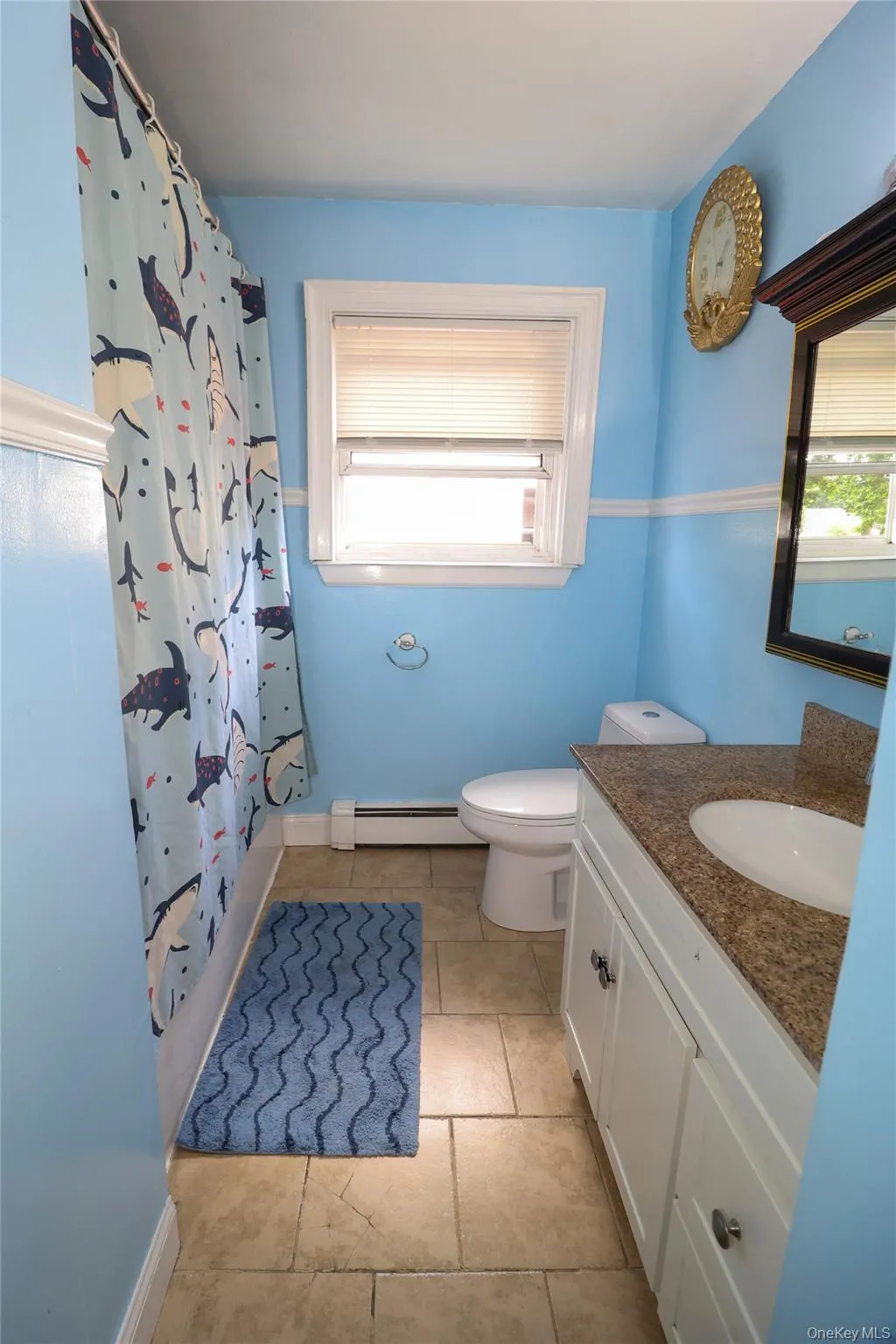Bathroom featuring a vanity with a countertop, an integrated sink, and white cabinetry with silver-toned hardware Bathroom featuring a vanity with a countertop, an integrated sink, and white cabinetry with silver-toned hardware
