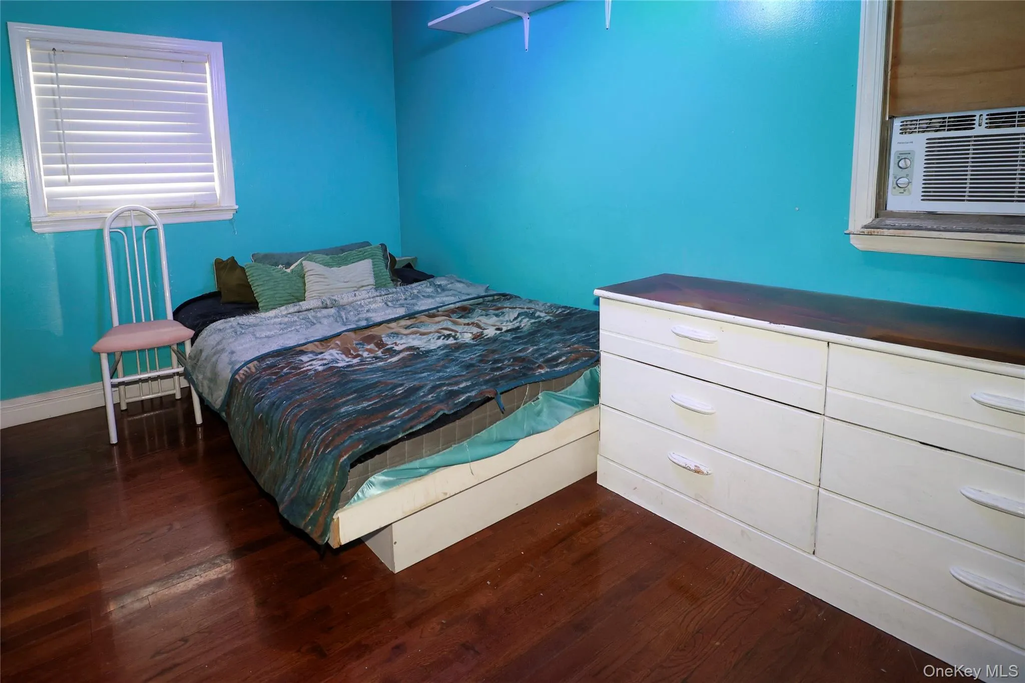 Wood-finish flooring provides a rich foundation for this space, complemented by a window with horizontal blinds for natural light control Wood-finish flooring provides a rich foundation for this space, complemented by a window with horizontal blinds for natural light control