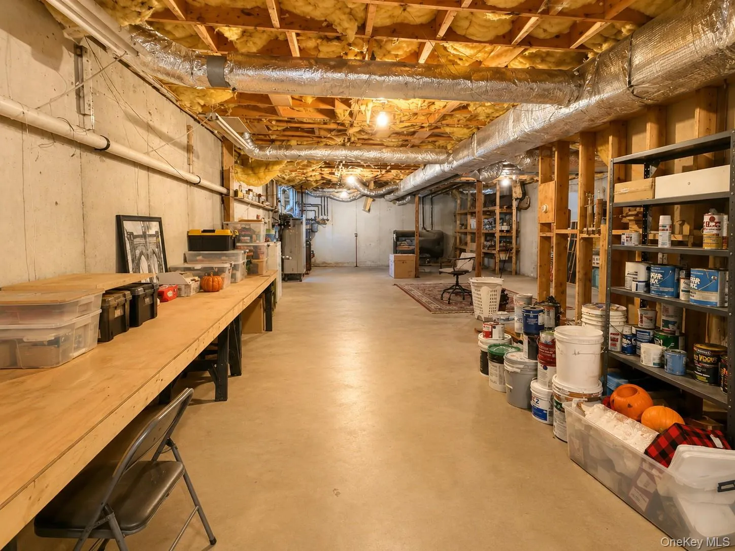 Unfinished basement featuring exposed wood joists, concrete flooring, Radiant heat and ample storage shelving Unfinished basement featuring exposed wood joists, concrete flooring, Radiant heat and ample storage shelving