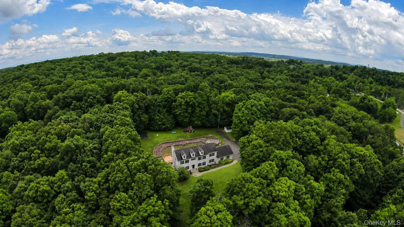Expansive wooded acreage featuring a large two story Colonial with multiple dormer windows Expansive wooded acreage featuring a large two story Colonial with multiple dormer windows