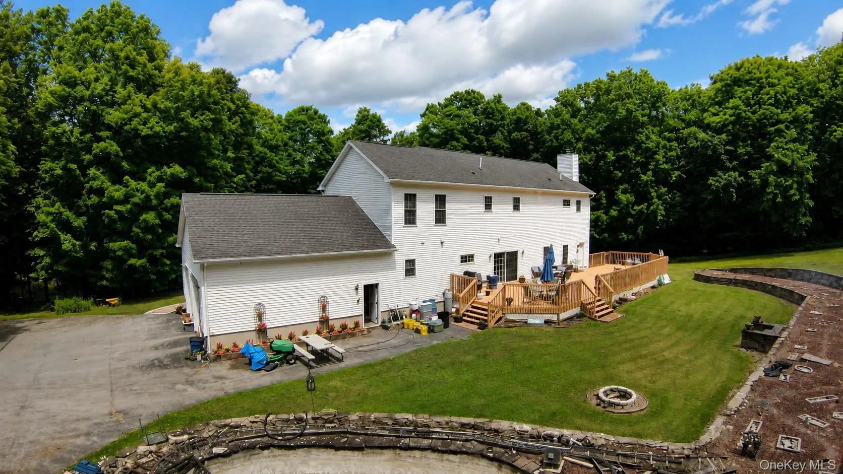 Back yard with large deck and stone walls throughout Back yard with large deck and stone walls throughout
