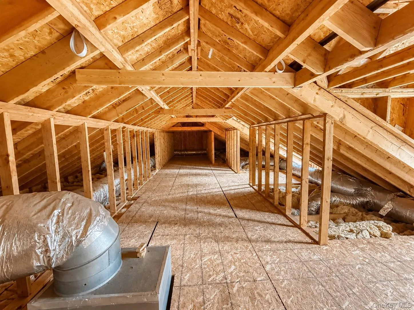Framed attic space featuring exposed wood rafter system, subflooring, and existing ductwork Framed attic space featuring exposed wood rafter system, subflooring, and existing ductwork