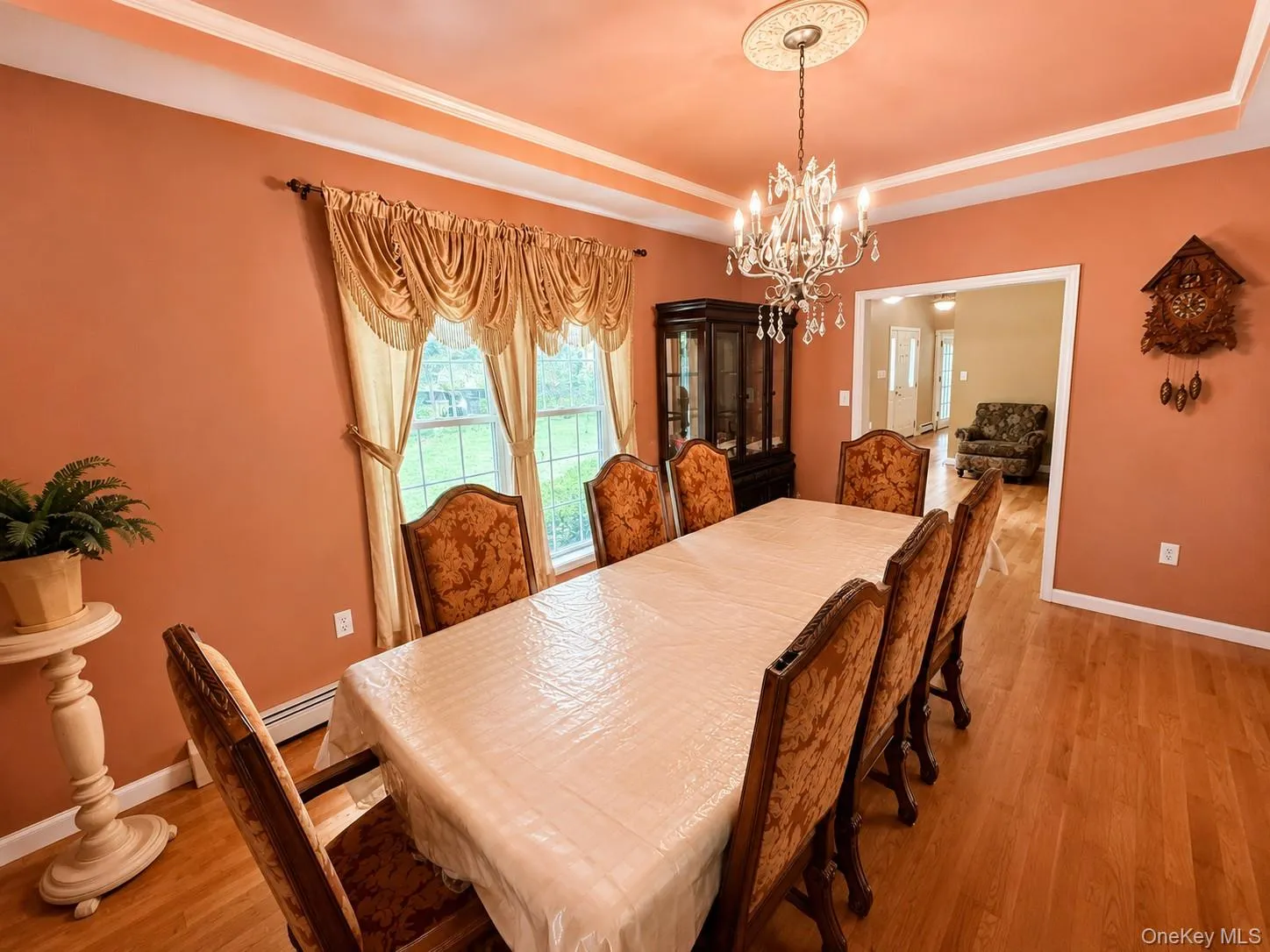 Dining area featuring wood-finish flooring, a tray ceiling with crown molding Dining area featuring wood-finish flooring, a tray ceiling with crown molding