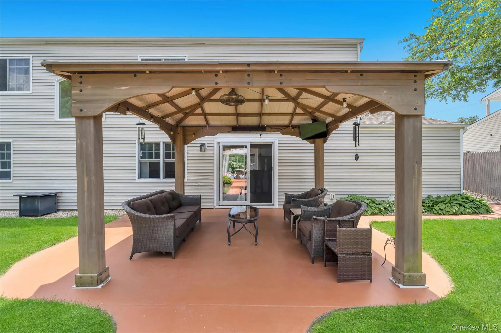 Expansive outdoor living area featuring a large wooden pergola with integrated lighting Expansive outdoor living area featuring a large wooden pergola with integrated lighting