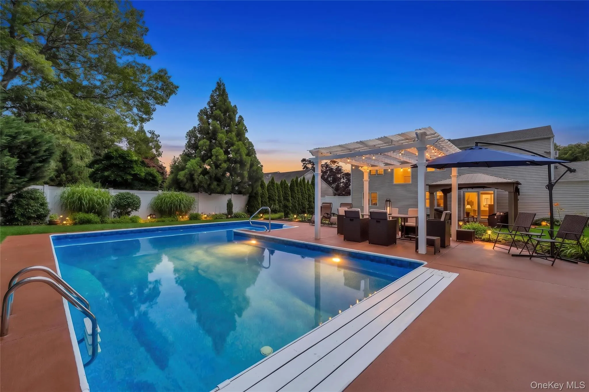 In-ground swimming pool with integrated spa and ample surrounding patio space. AI generated lighting In-ground swimming pool with integrated spa and ample surrounding patio space. AI generated lighting