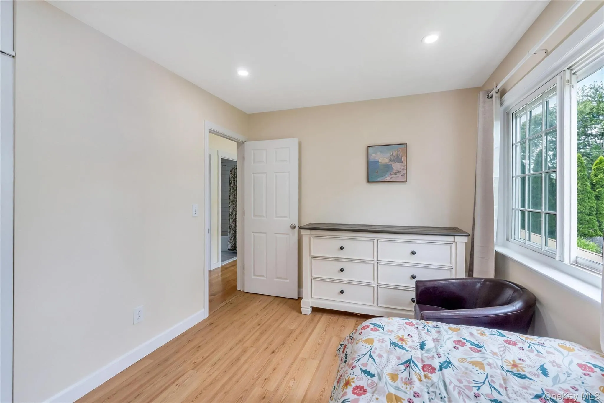 Room with wood-finish flooring, recessed lighting, and a multi-pane window Room with wood-finish flooring, recessed lighting, and a multi-pane window