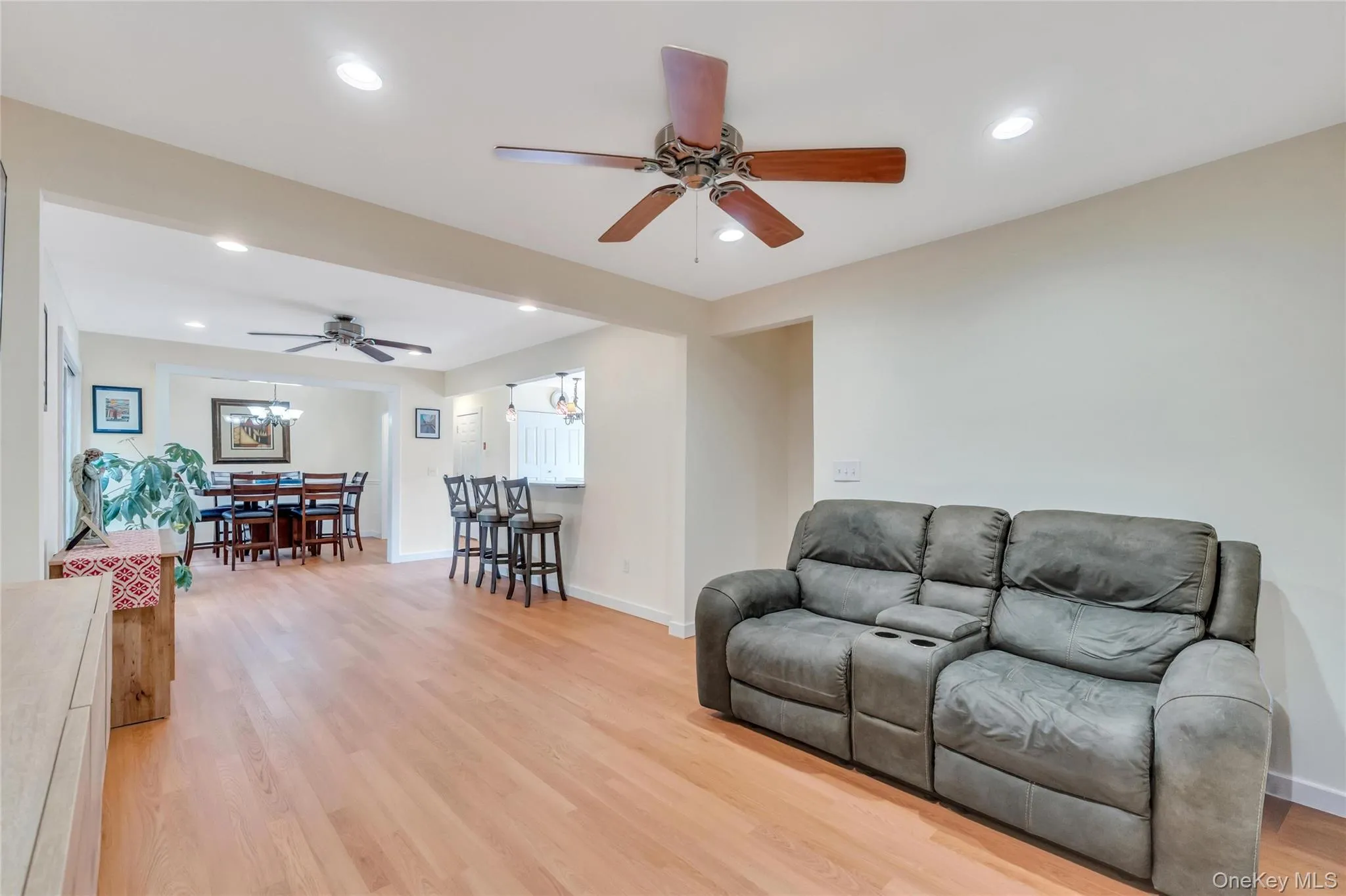 Bright interior featuring wood-finish flooring, recessed lighting, and a ceiling fan Bright interior featuring wood-finish flooring, recessed lighting, and a ceiling fan
