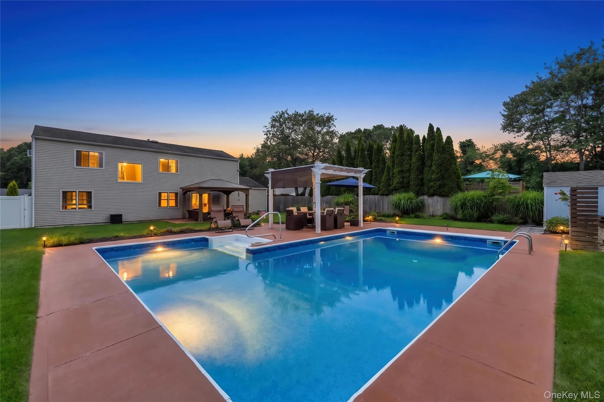 Expansive backyard featuring a rectangular swimming pool with integrated steps, a surrounding concrete patio, and a covered pergola with built-in seating. AI generated lighting. Expansive backyard featuring a rectangular swimming pool with integrated steps, a surrounding concrete patio, and a covered pergola with built-in seating. AI generated lighting.