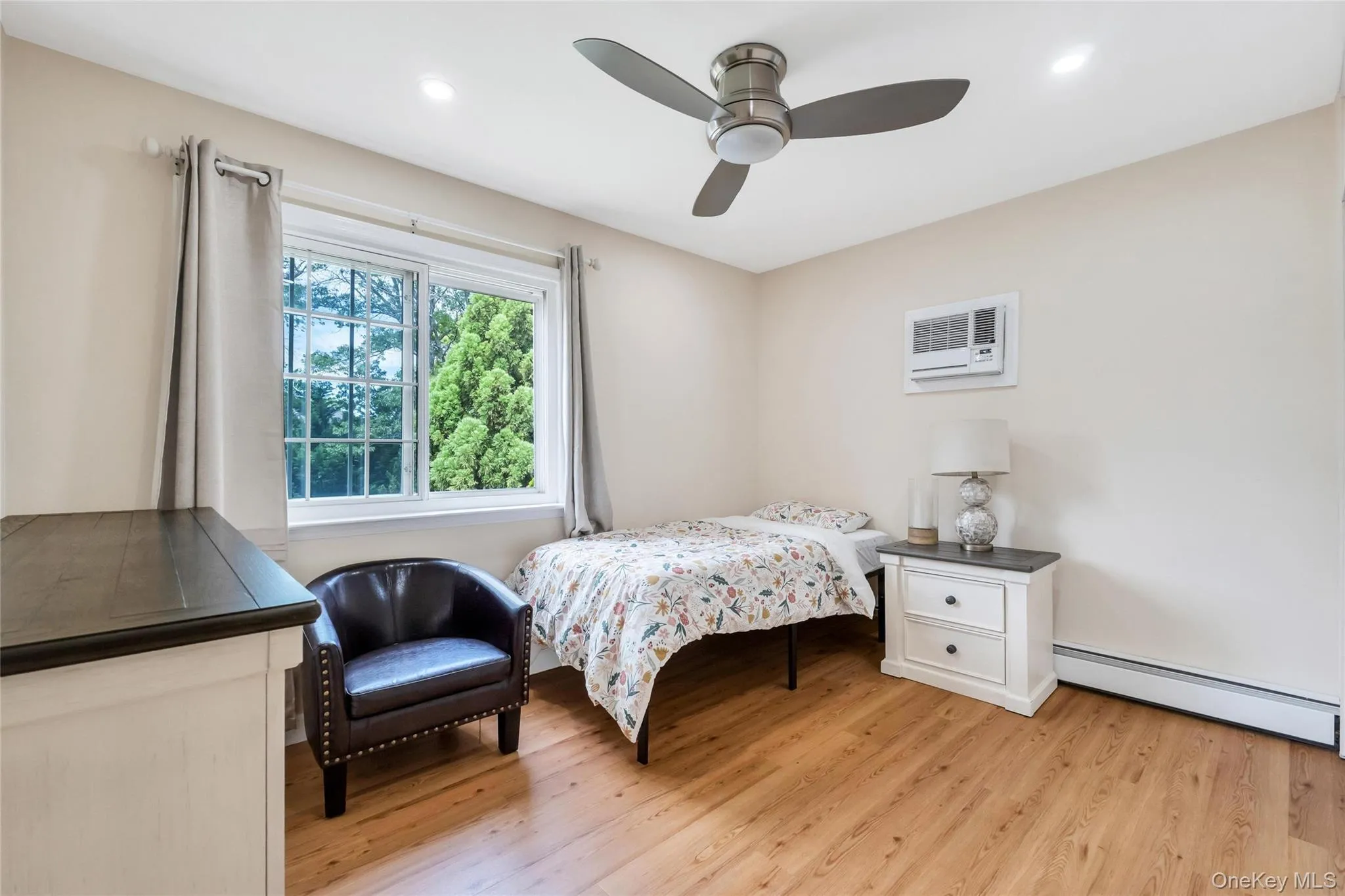 Room featuring wood-finish flooring, a window with exterior tree views, recessed lighting, and a ceiling fan Room featuring wood-finish flooring, a window with exterior tree views, recessed lighting, and a ceiling fan