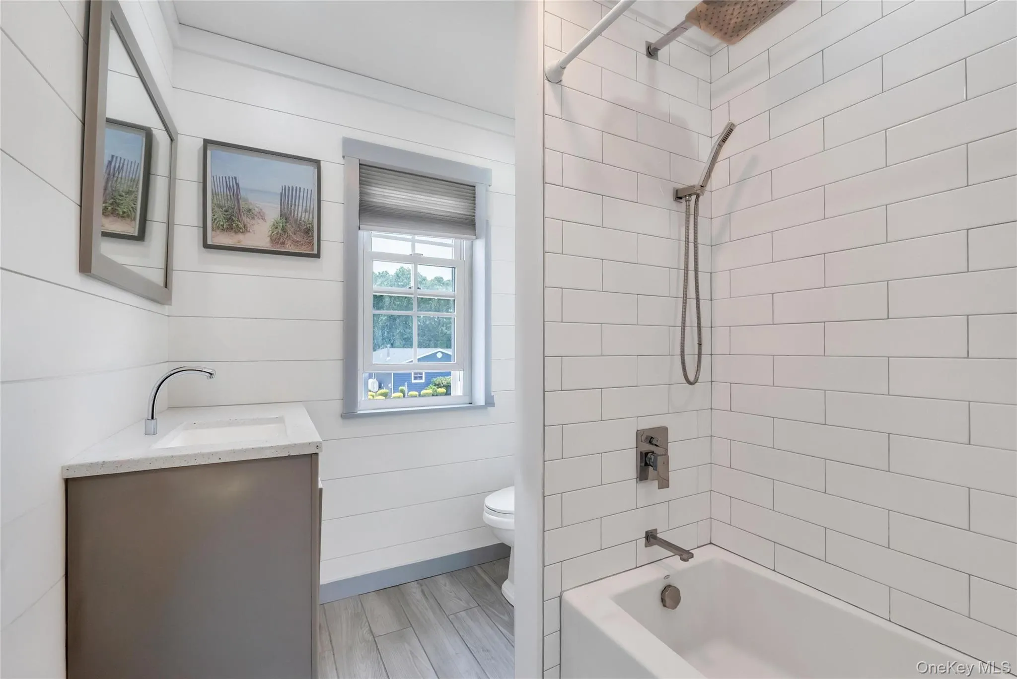 Bathroom featuring a built-in bathtub with subway tile surround, a rain shower head, and a handheld shower fixture Bathroom featuring a built-in bathtub with subway tile surround, a rain shower head, and a handheld shower fixture