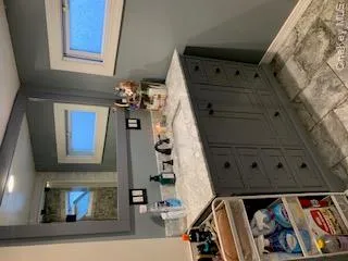 Bathroom vanity featuring a light-colored countertop, integrated sink, and dark gray cabinetry with multiple drawers and cabinet doors Bathroom vanity featuring a light-colored countertop, integrated sink, and dark gray cabinetry with multiple drawers and cabinet doors