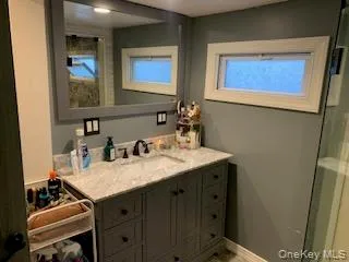 Bathroom vanity with a gray finish, solid surface countertop, and undermount sink Bathroom vanity with a gray finish, solid surface countertop, and undermount sink