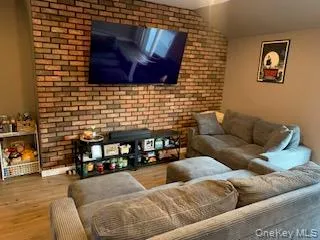 Exposed brick accent wall with a wall-mounted television Exposed brick accent wall with a wall-mounted television
