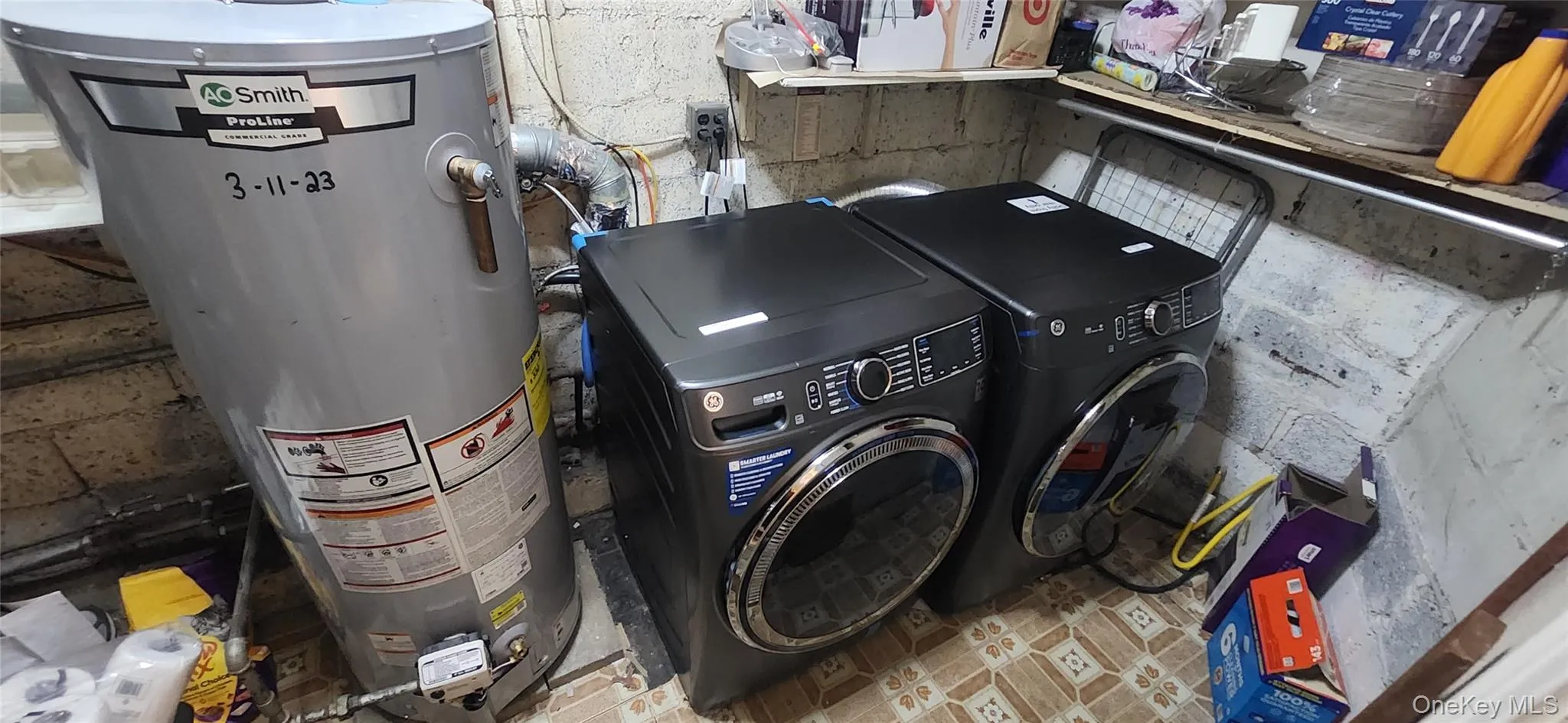 Laundry room with washer and clothes dryer and water heater Laundry room with washer and clothes dryer and water heater