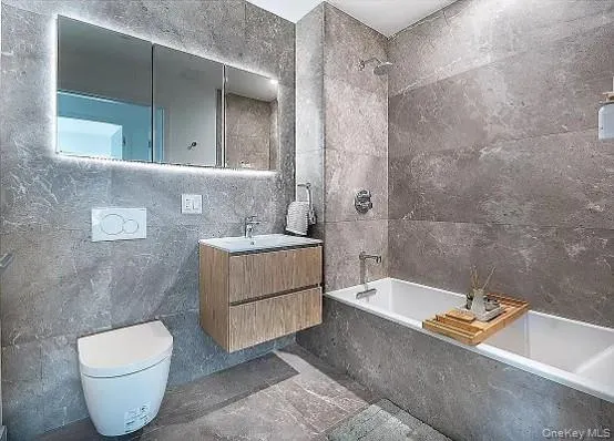 Modern bathroom featuring full-height stone-look tile walls and flooring Modern bathroom featuring full-height stone-look tile walls and flooring