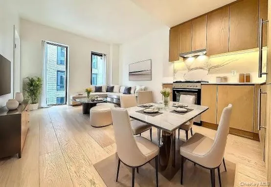 Open-concept living space featuring wood-finish flooring, a contemporary kitchen with wood cabinetry and stone backsplash, and floor-to-ceiling windows Open-concept living space featuring wood-finish flooring, a contemporary kitchen with wood cabinetry and stone backsplash, and floor-to-ceiling windows