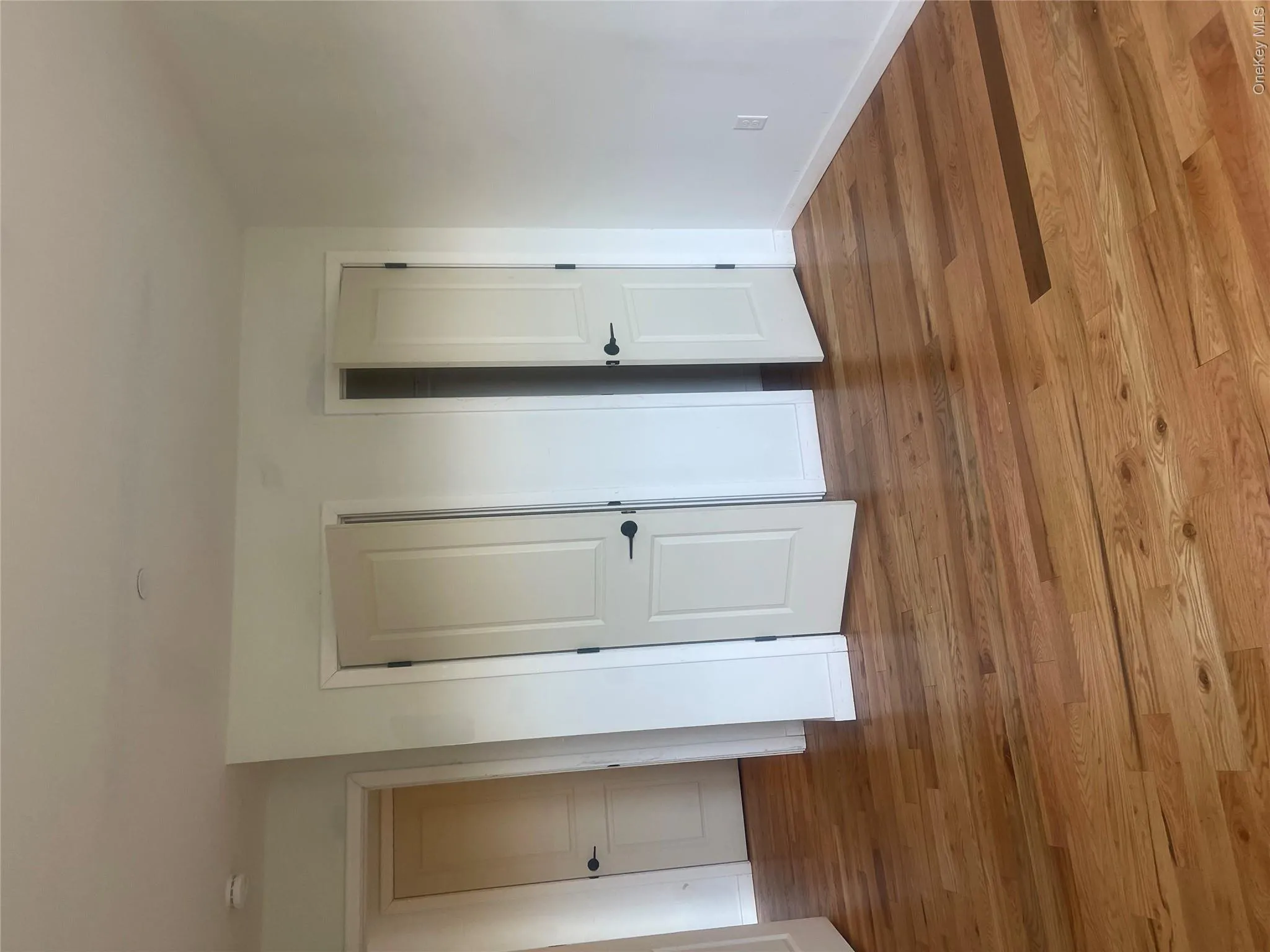 Hardwood flooring extending throughout, complemented by white walls and his and her closets Hardwood flooring extending throughout, complemented by white walls and his and her closets