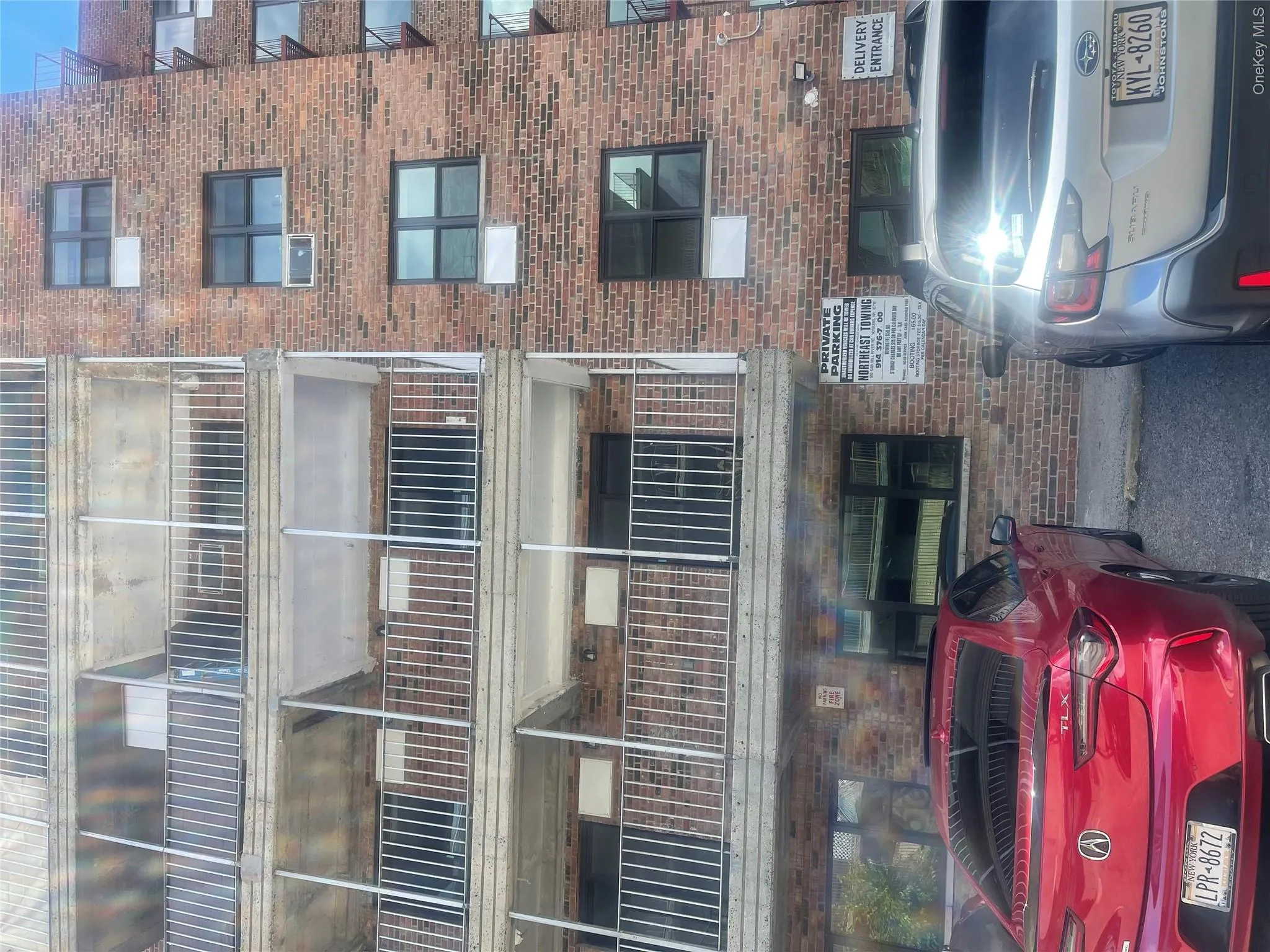 Brick facade multi-story building featuring multiple private balconies with metal railings Brick facade multi-story building featuring multiple private balconies with metal railings
