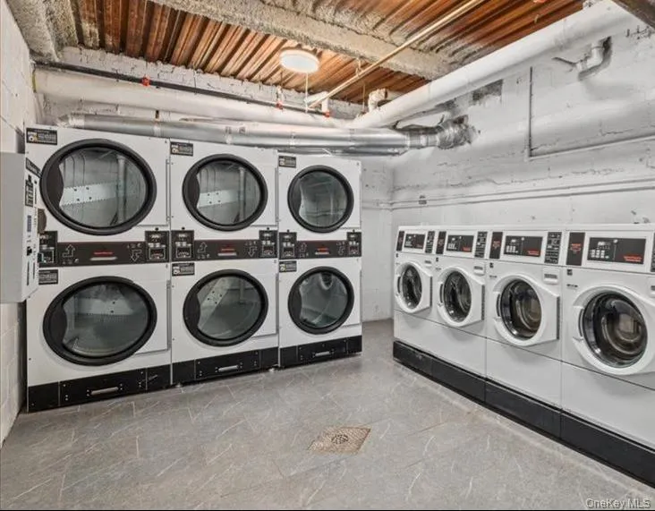 Dedicated laundry facility featuring multiple commercial-grade washers and stacked dryers Dedicated laundry facility featuring multiple commercial-grade washers and stacked dryers