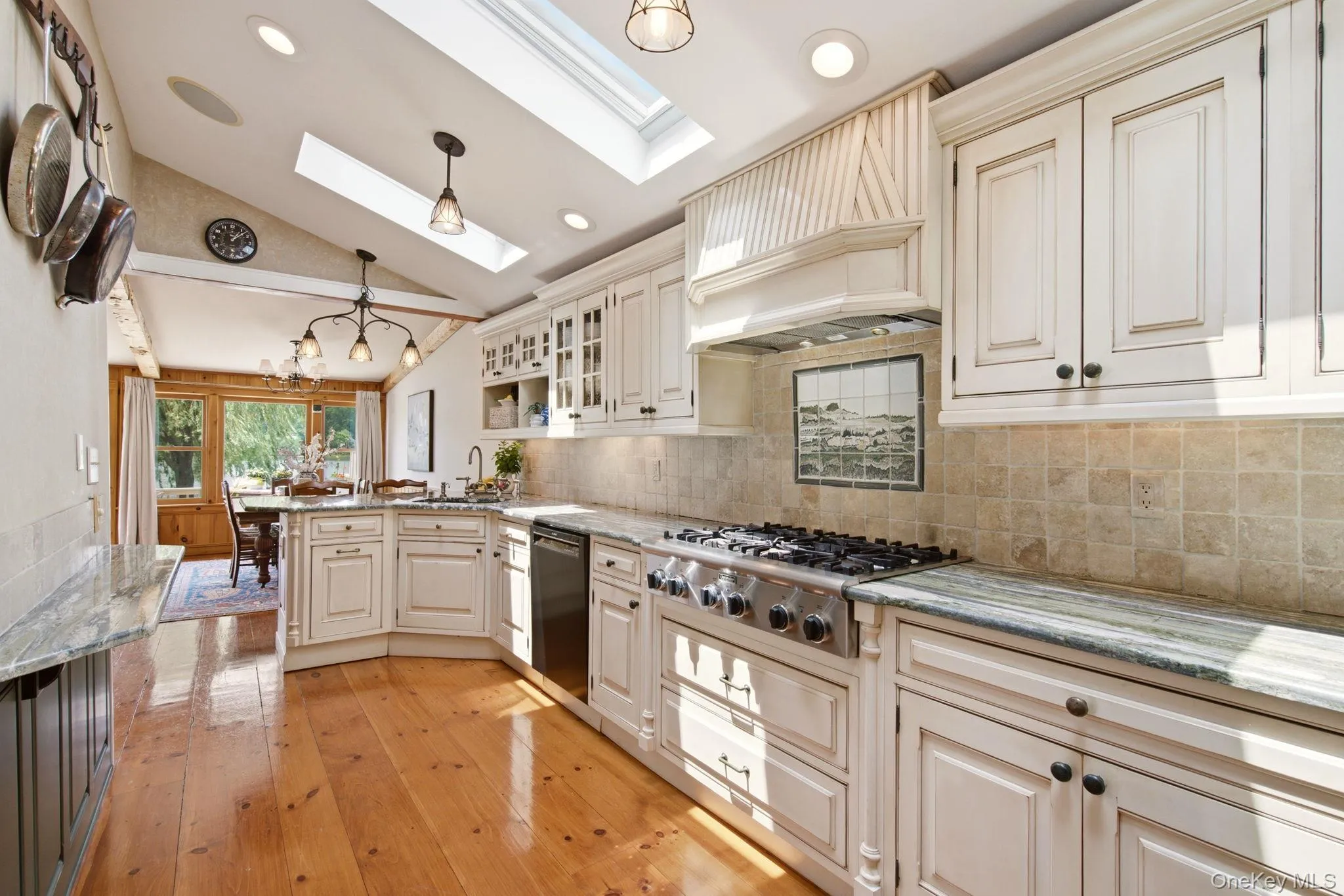 Stone backsplash with framed mural behind the Thermodore 6-burner gas range. Stone backsplash with framed mural behind the Thermodore 6-burner gas range.
