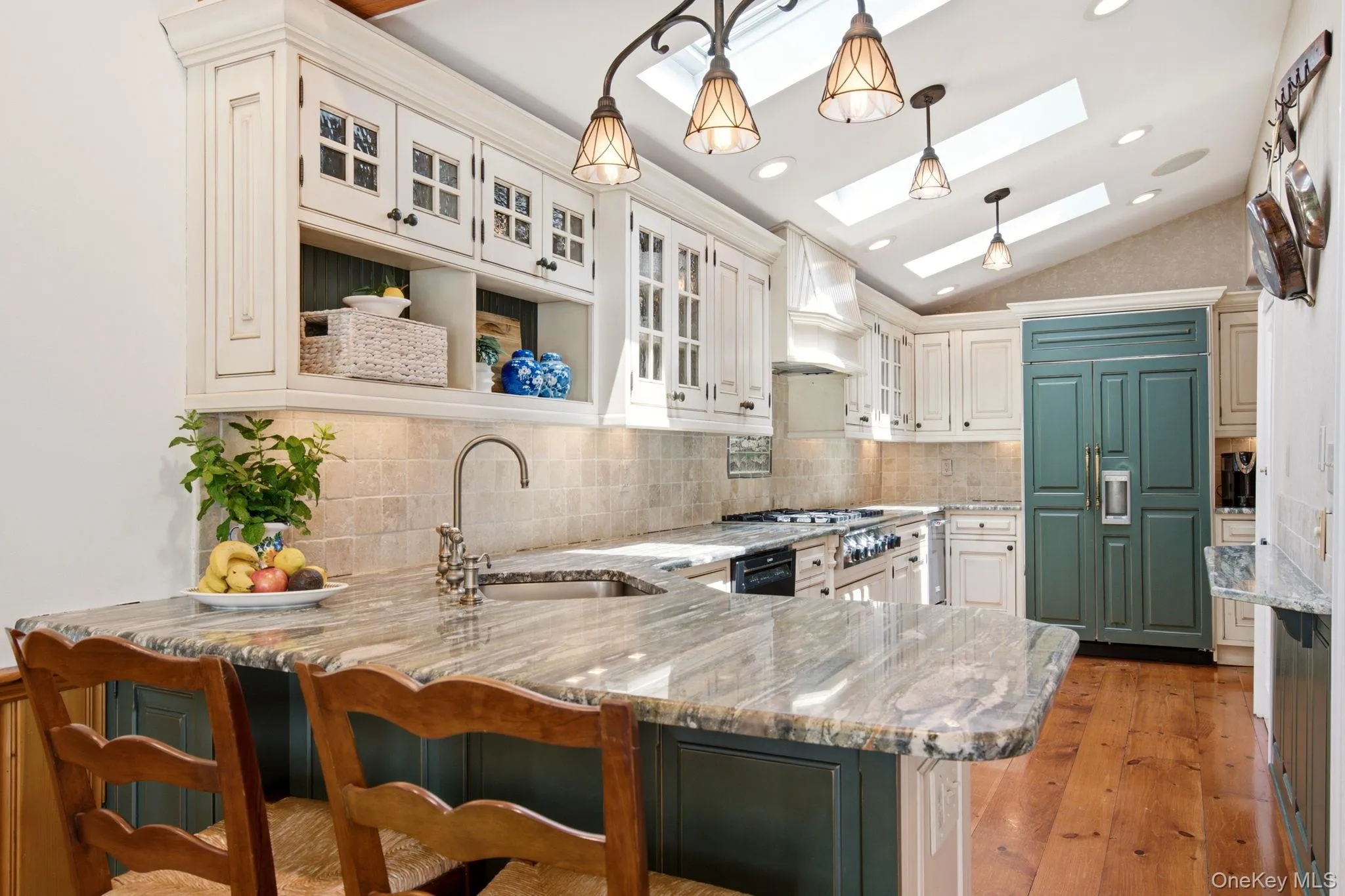 Custom cream colored cabinetry with hunter green colored island and refridgerator. Custom cream colored cabinetry with hunter green colored island and refridgerator.