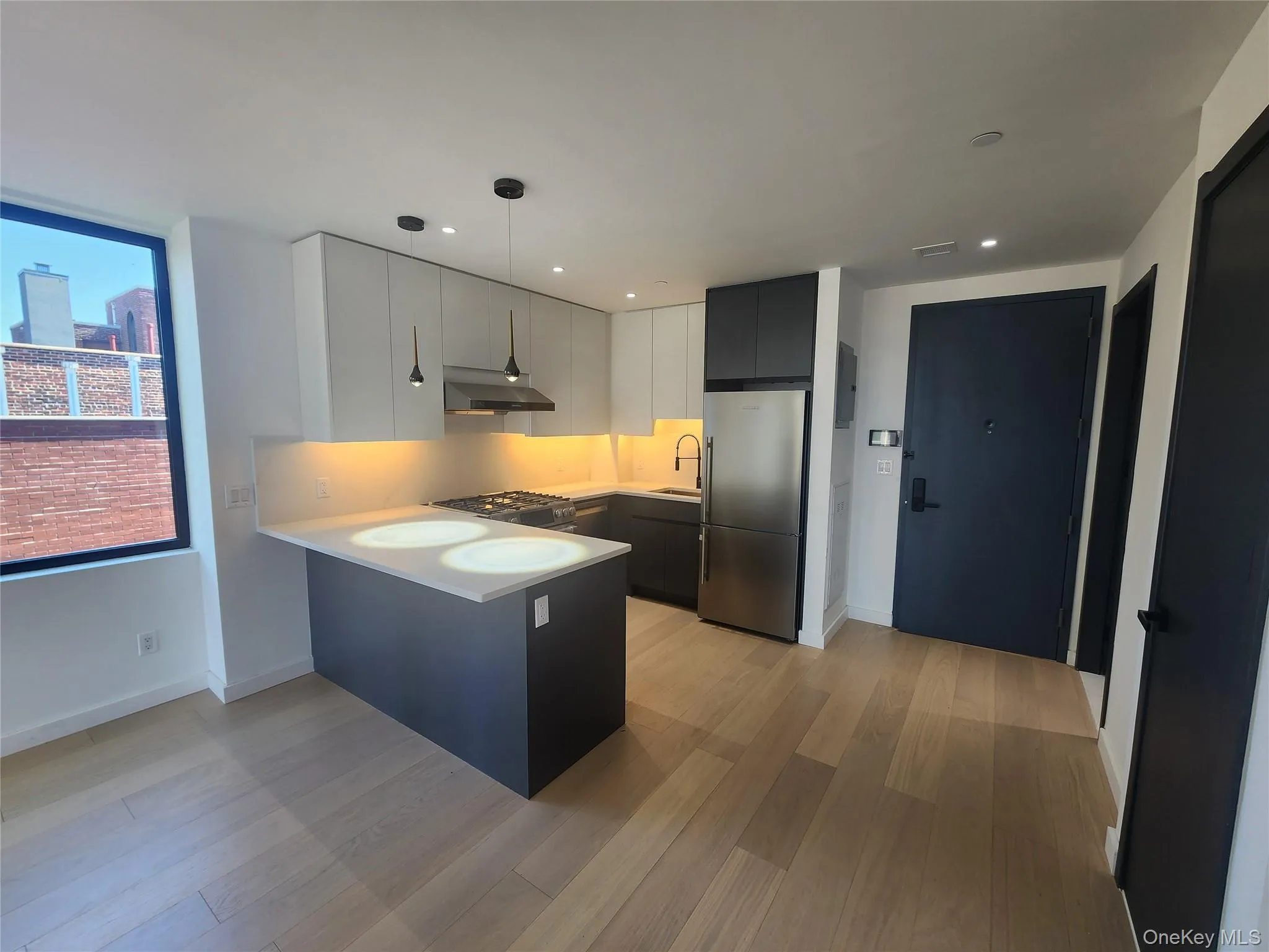 Modern kitchen featuring sleek white upper cabinetry, dark lower cabinetry, and light-toned countertops Modern kitchen featuring sleek white upper cabinetry, dark lower cabinetry, and light-toned countertops