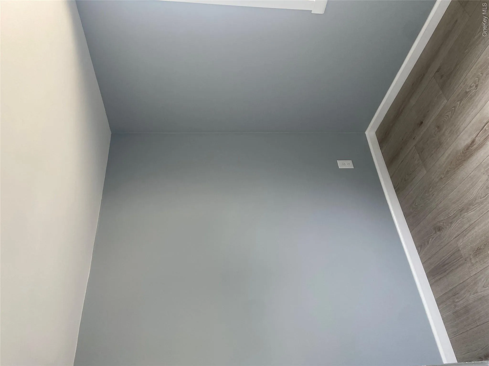 Light gray walls with white trim and wood-finish flooring Light gray walls with white trim and wood-finish flooring