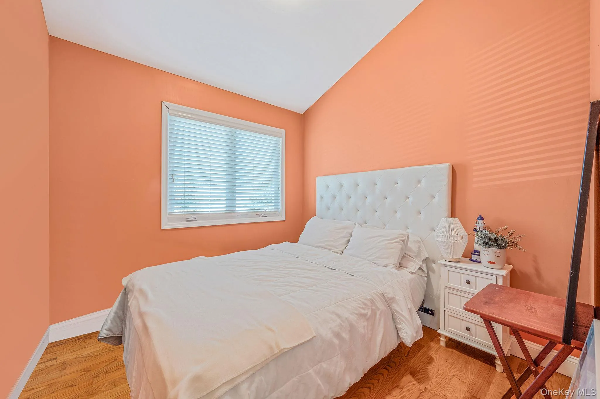 Bedroom with light wood-style floors and lofted ceiling Bedroom with light wood-style floors and lofted ceiling