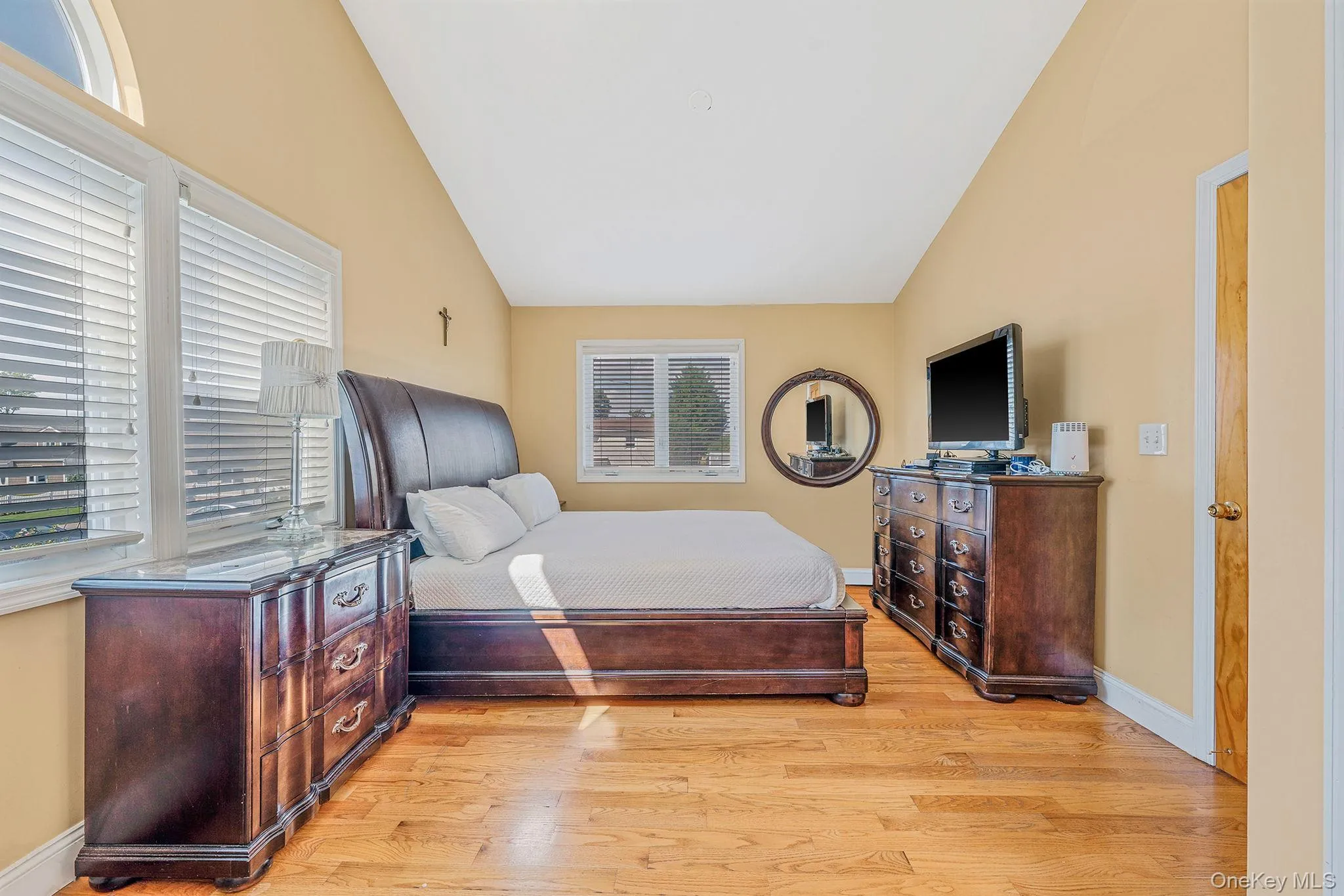 Bedroom featuring lofted ceiling and light wood-type flooring Bedroom featuring lofted ceiling and light wood-type flooring