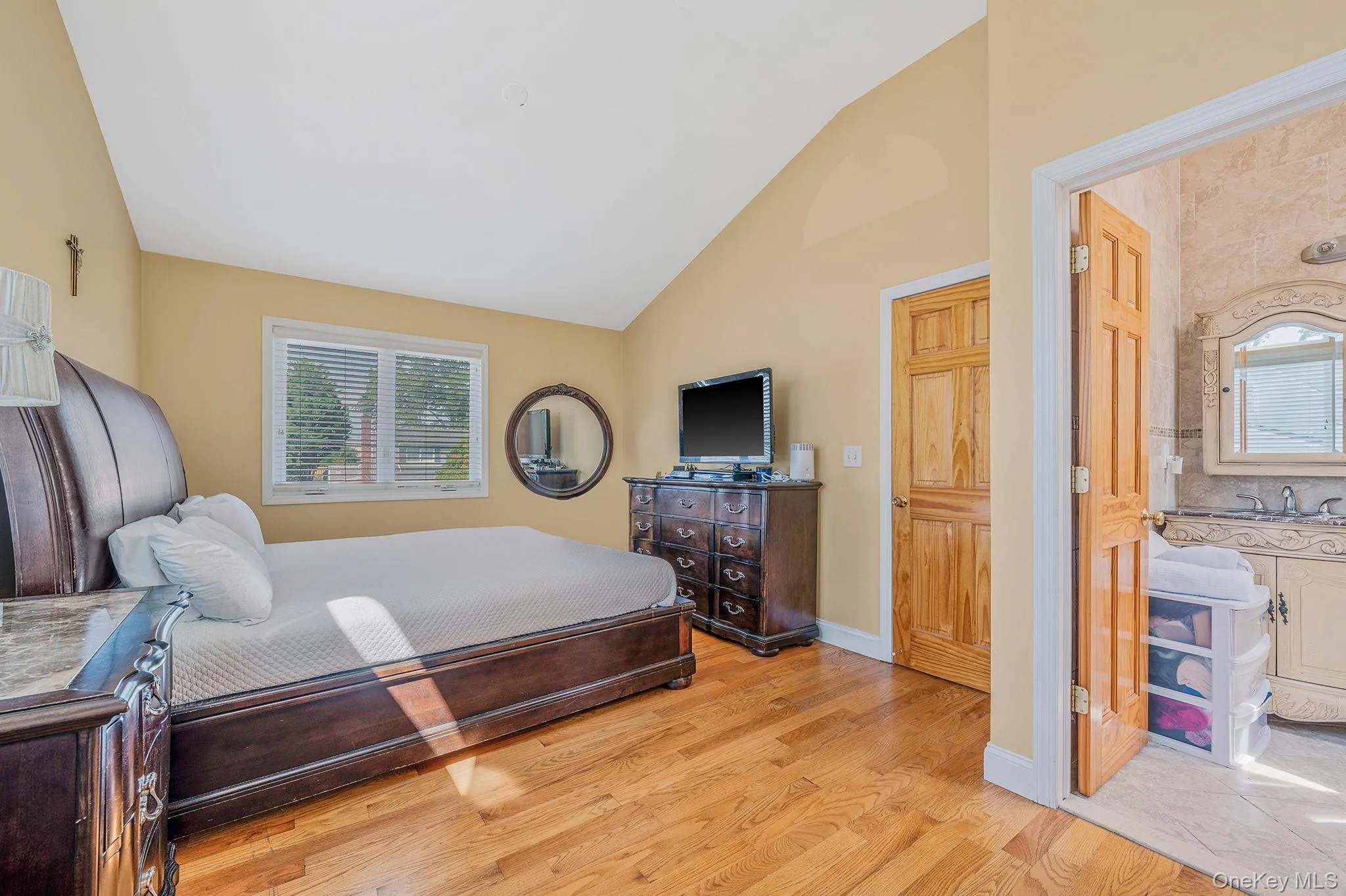 Bedroom with vaulted ceiling and light wood-style flooring Bedroom with vaulted ceiling and light wood-style flooring