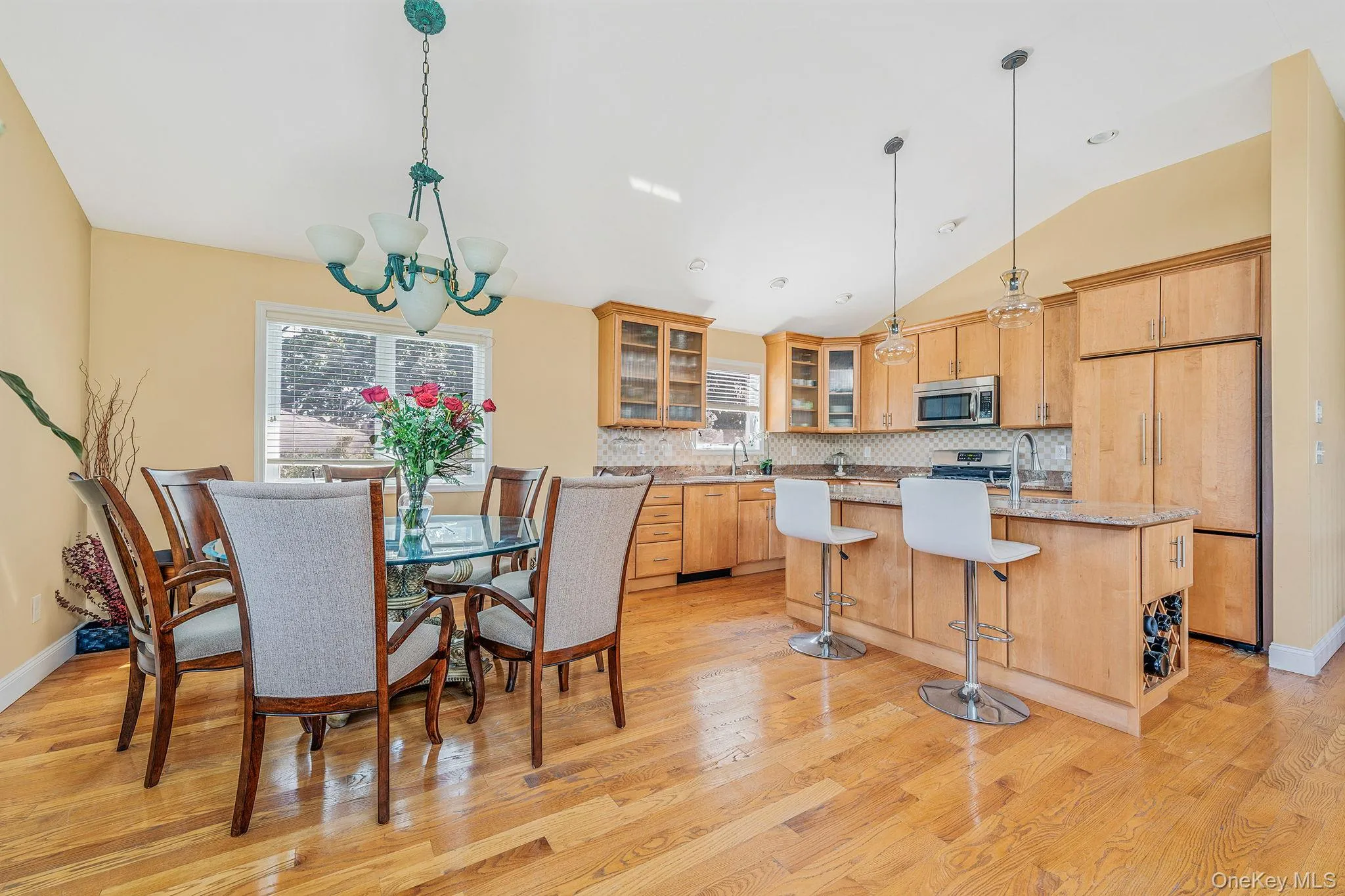 Dining space featuring lofted ceiling, light wood-style floors, and a chandelier Dining space featuring lofted ceiling, light wood-style floors, and a chandelier
