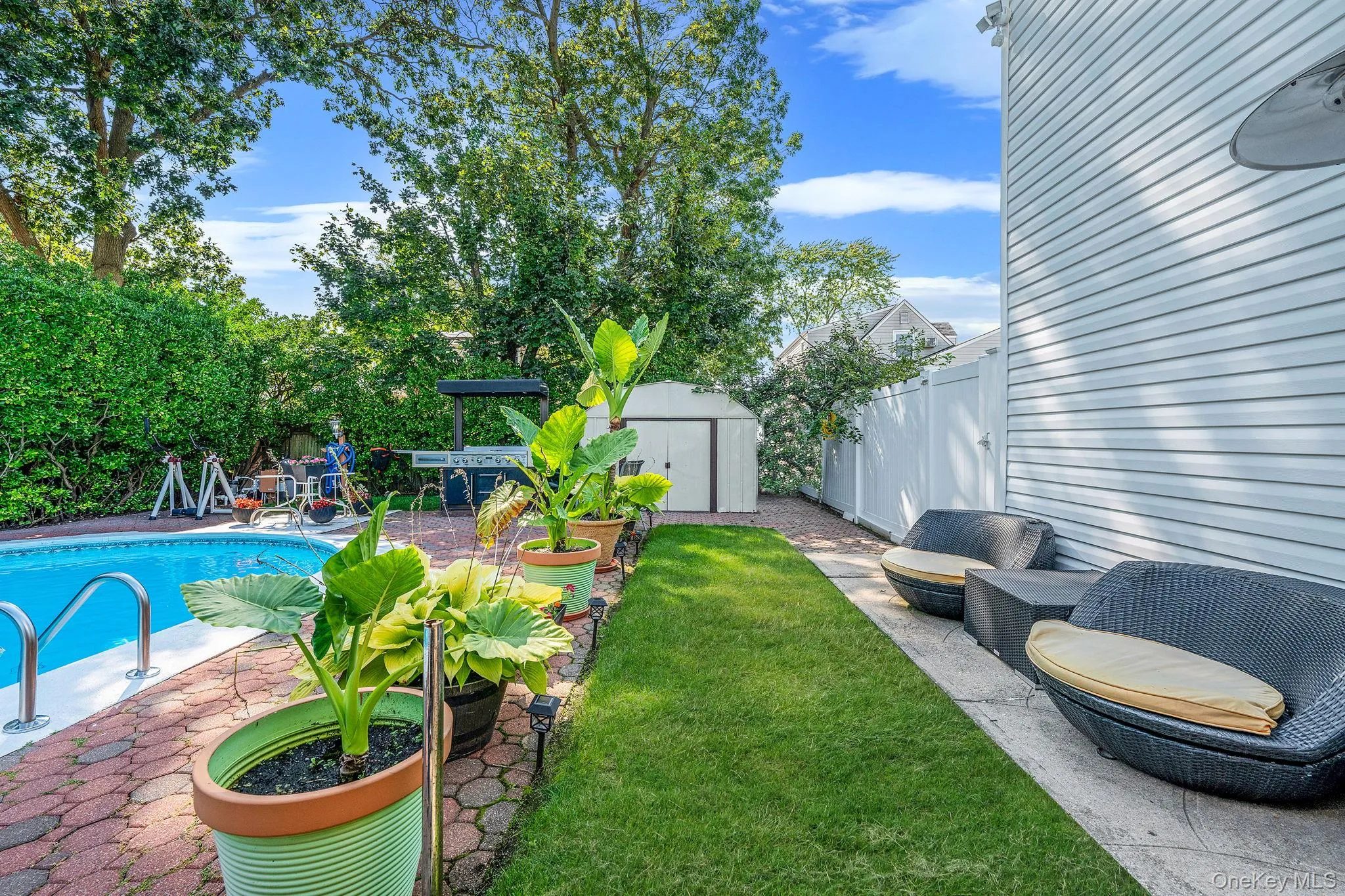 Fenced backyard with a patio and a storage shed Fenced backyard with a patio and a storage shed