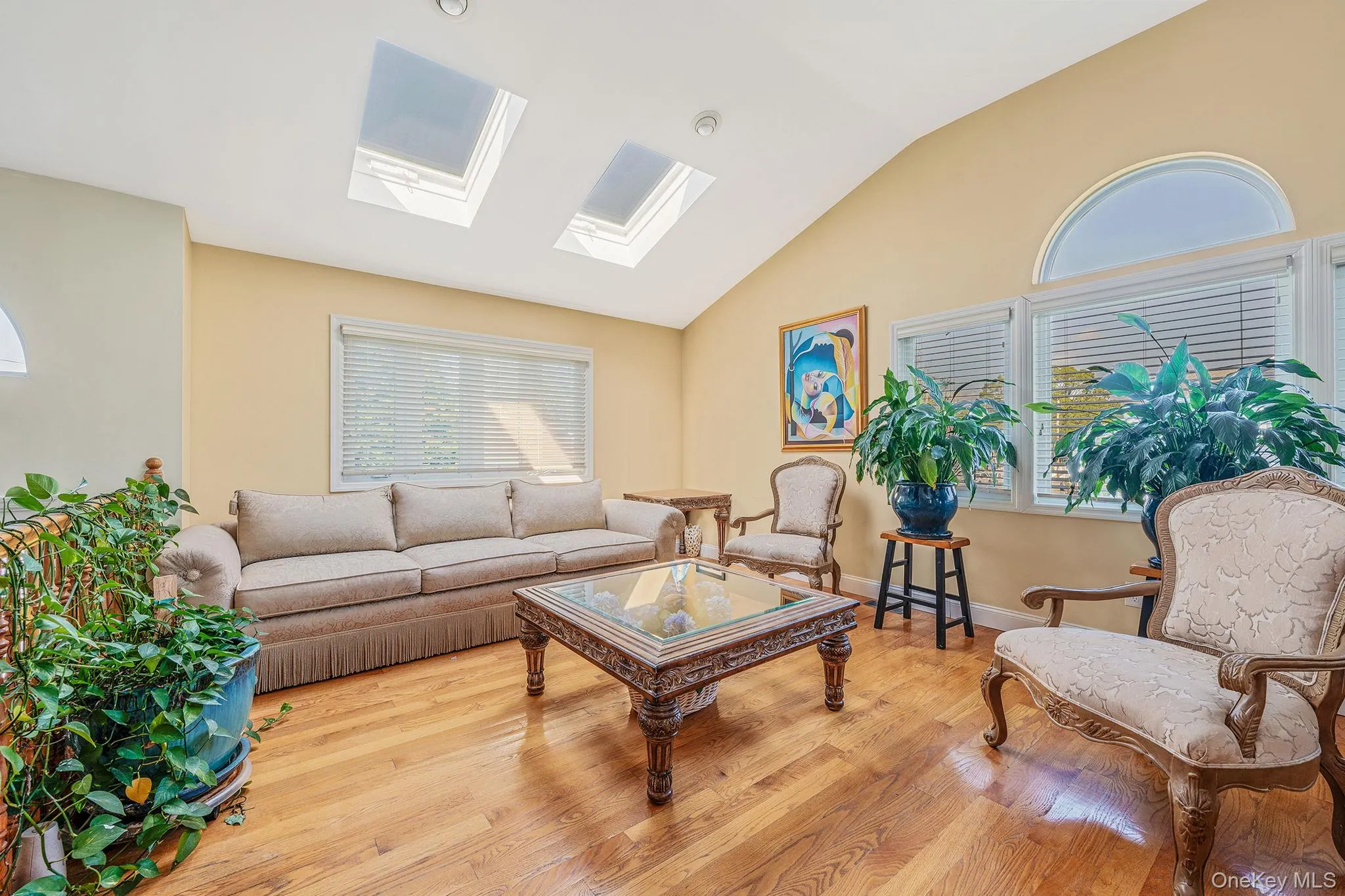 Living area featuring vaulted ceiling, a skylight, and wood finished floors Living area featuring vaulted ceiling, a skylight, and wood finished floors