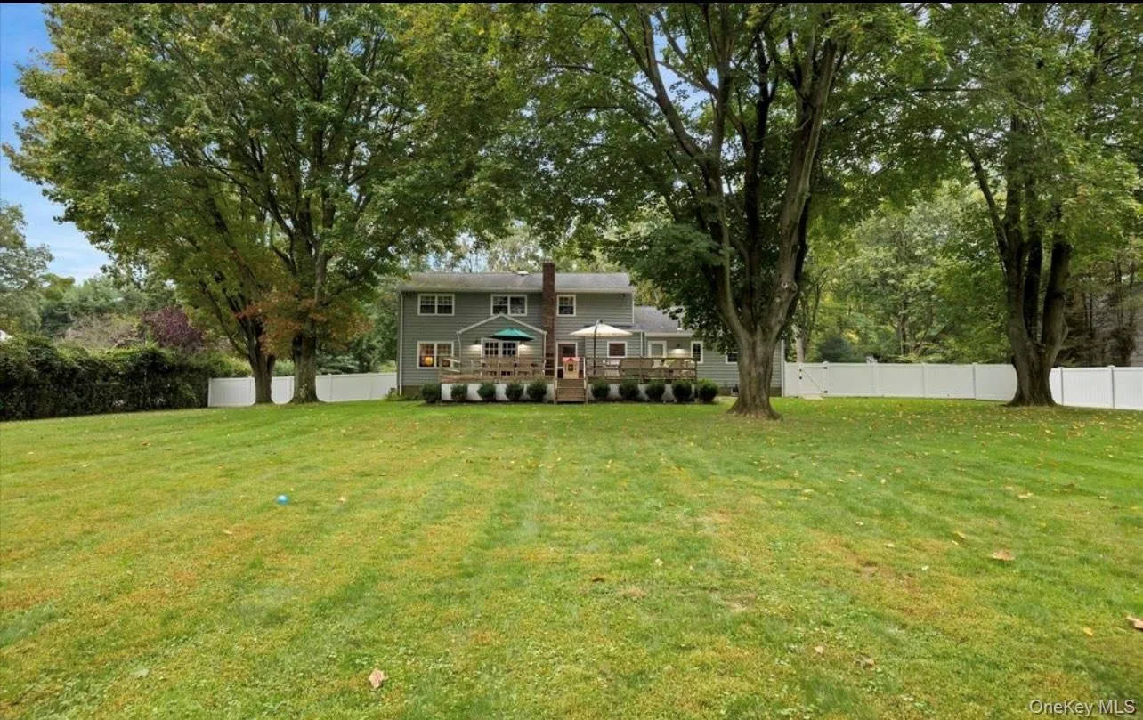View of yard featuring a deck and view of scattered trees View of yard featuring a deck and view of scattered trees