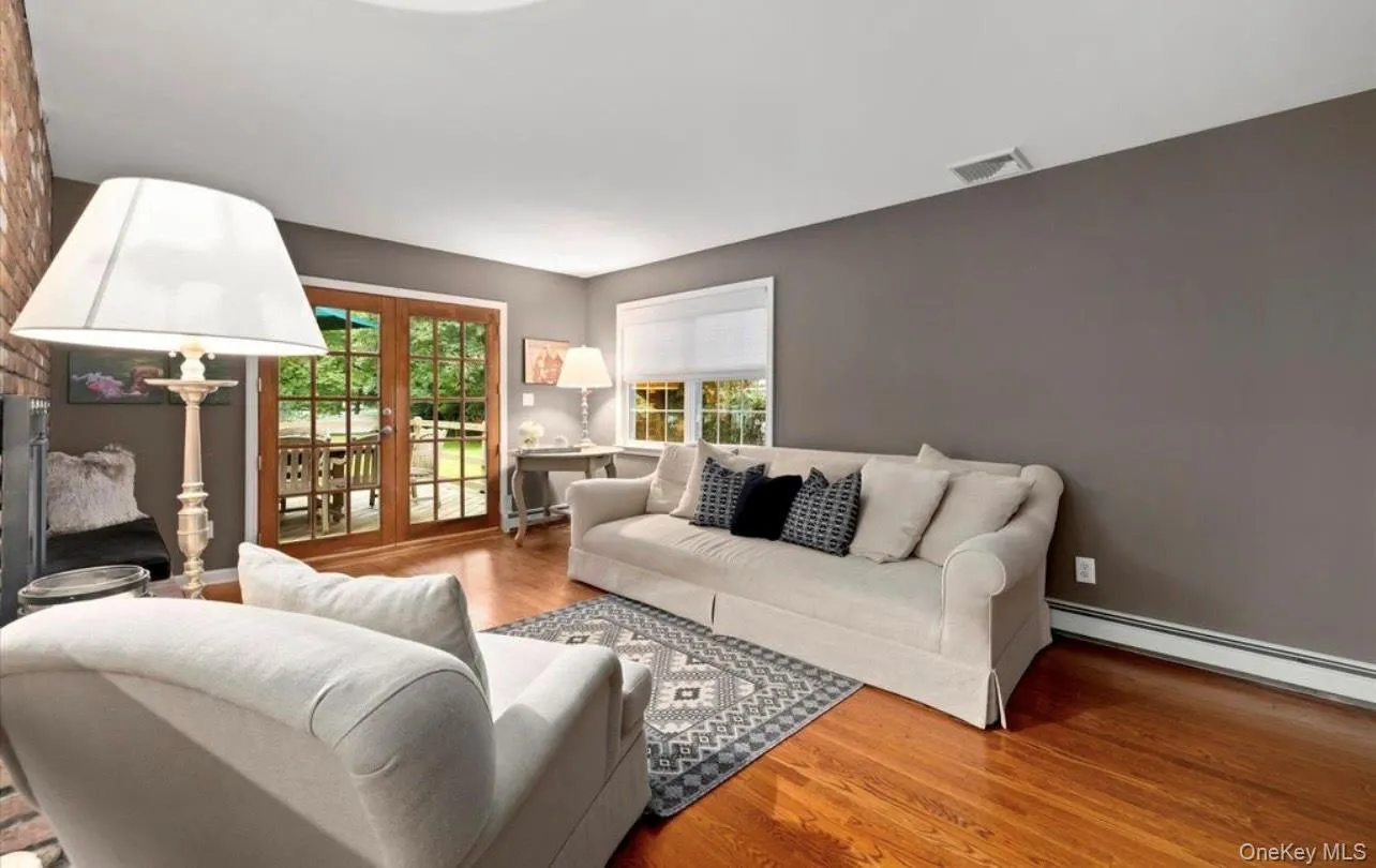 Living room with wood finished floors and a baseboard radiator Living room with wood finished floors and a baseboard radiator