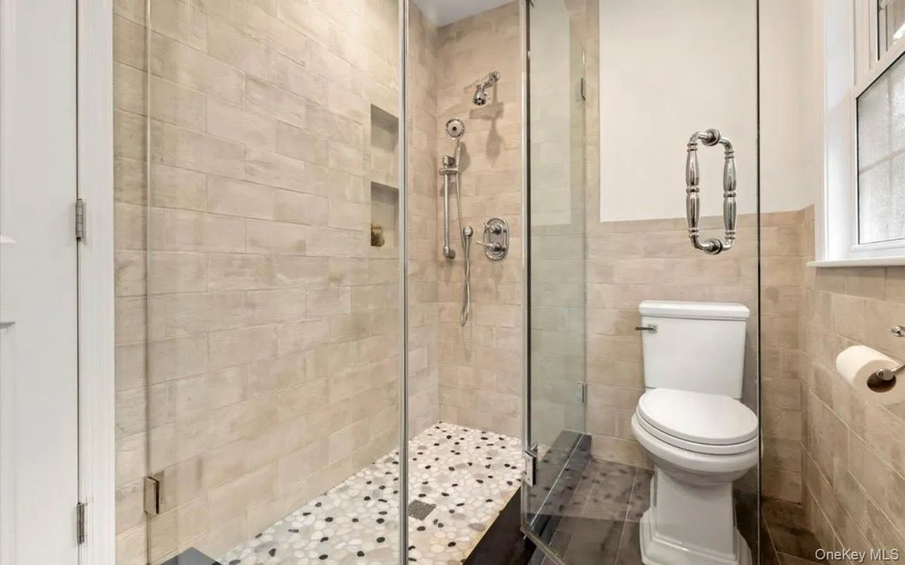 Full bath with a stall shower and tile walls Full bath with a stall shower and tile walls