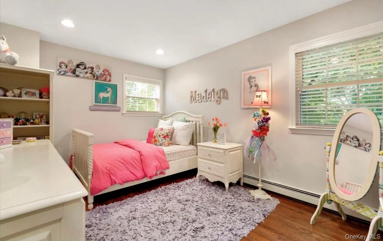 Bedroom featuring wood finished floors, a baseboard heating unit, and recessed lighting Bedroom featuring wood finished floors, a baseboard heating unit, and recessed lighting