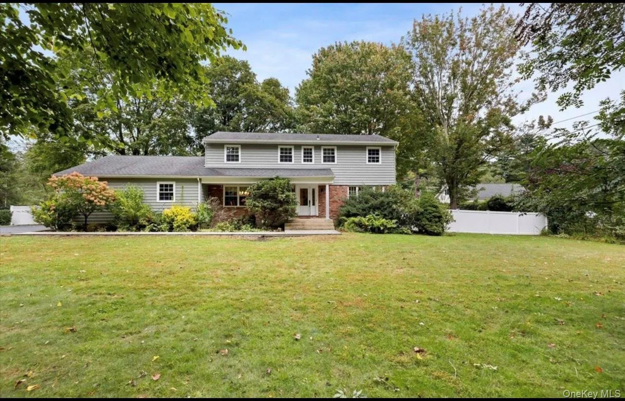 Traditional-style home with brick siding and view of scattered trees Traditional-style home with brick siding and view of scattered trees