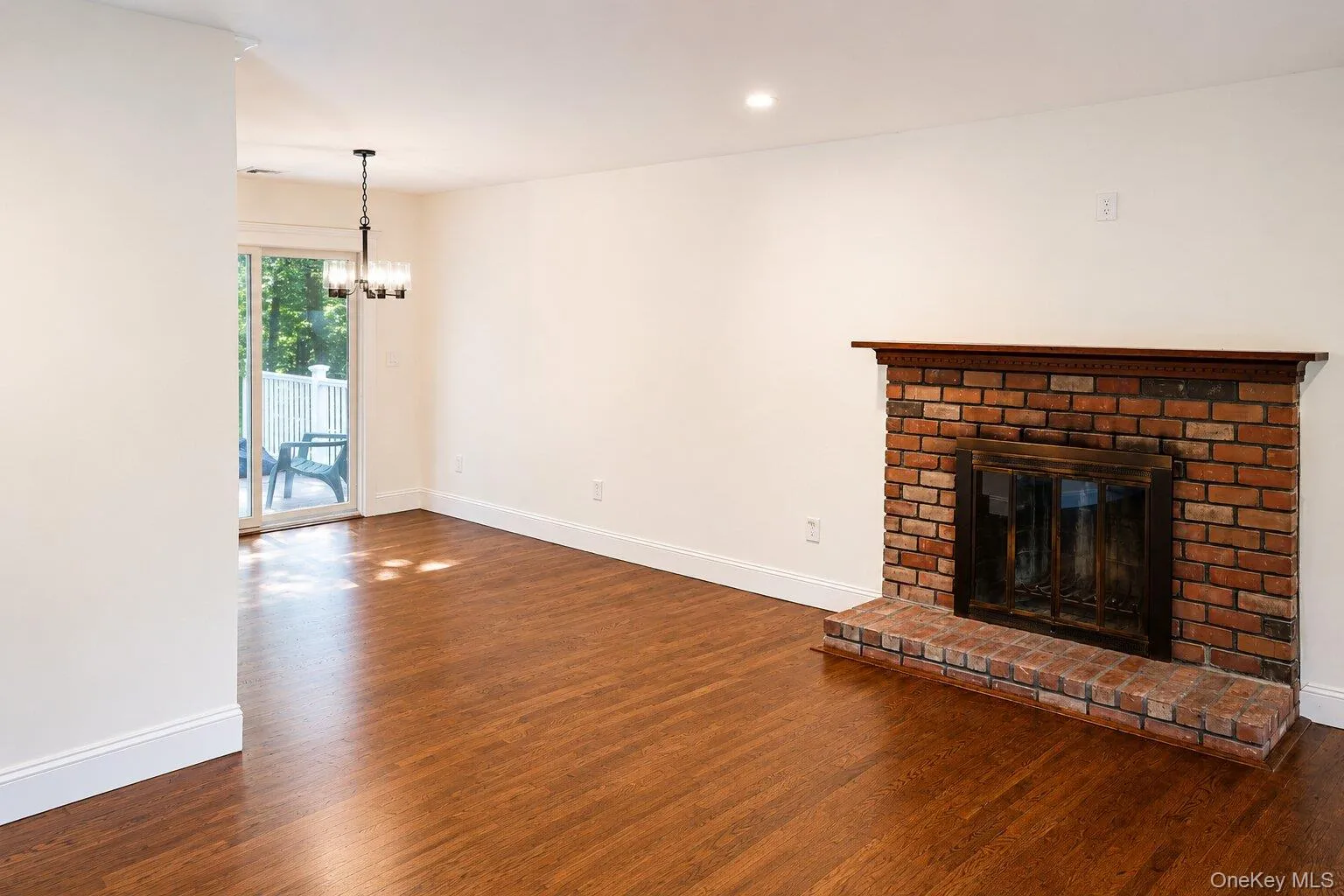 Living room fireplace, connecting to dining room and sliding door to deck Living room fireplace, connecting to dining room and sliding door to deck