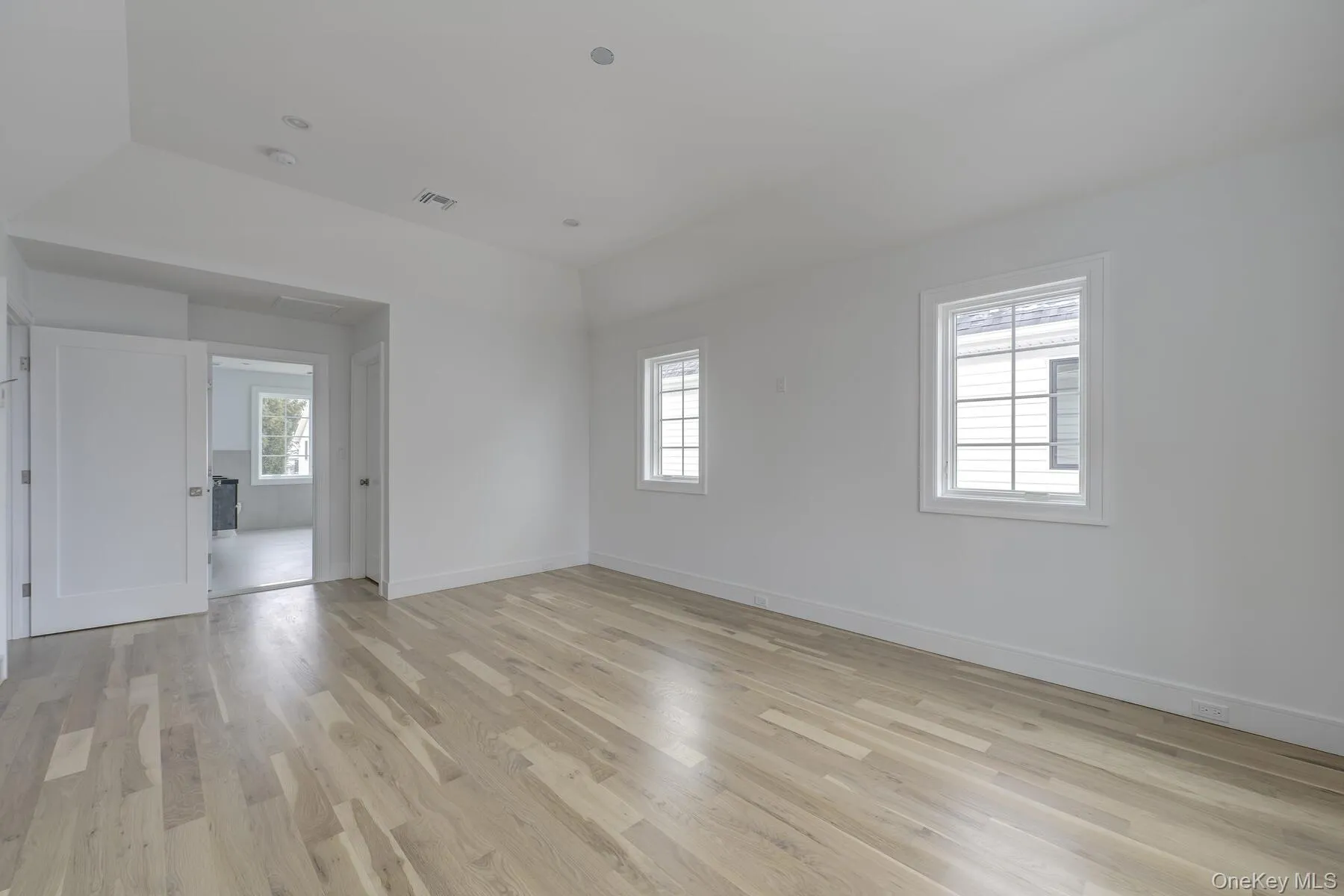 Empty room featuring light wood-style floors, baseboards, and visible vents Empty room featuring light wood-style floors, baseboards, and visible vents