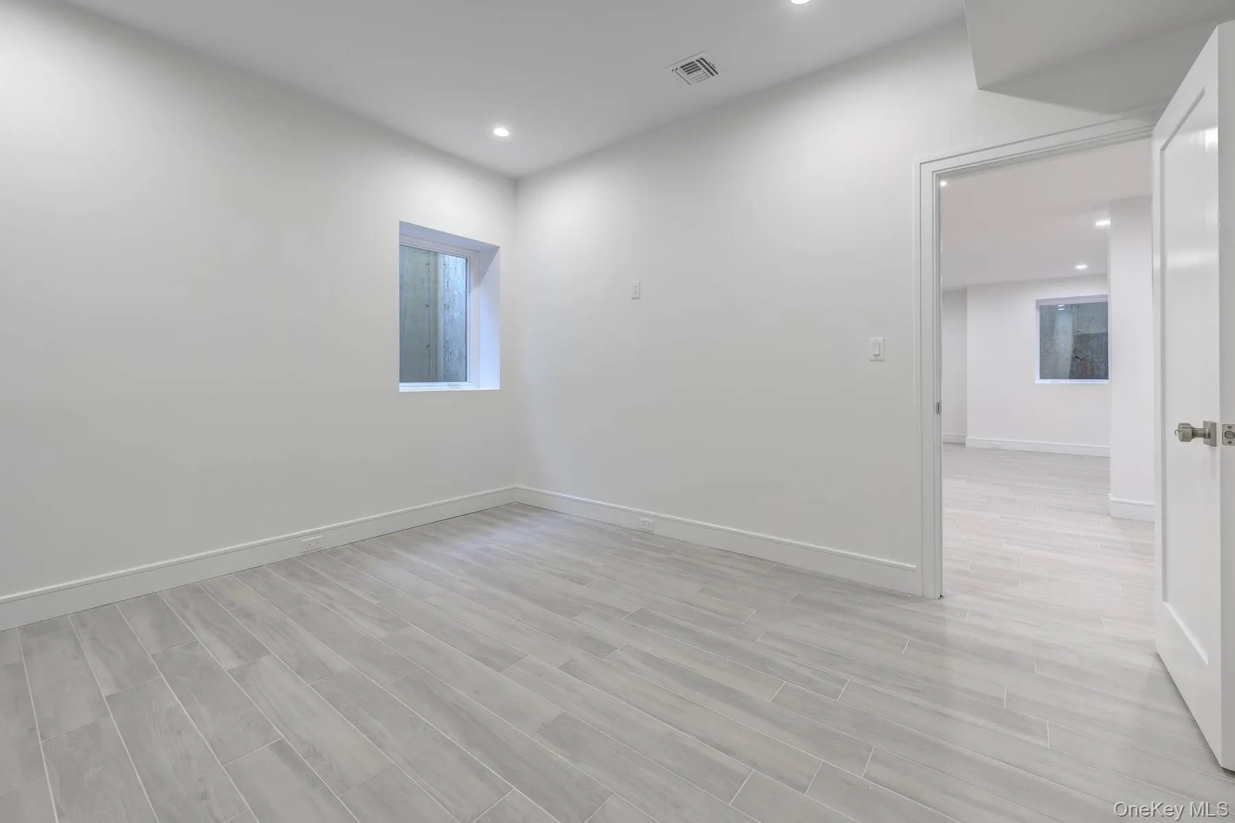 Empty room featuring light wood finished floors, recessed lighting, visible vents, and baseboards Empty room featuring light wood finished floors, recessed lighting, visible vents, and baseboards