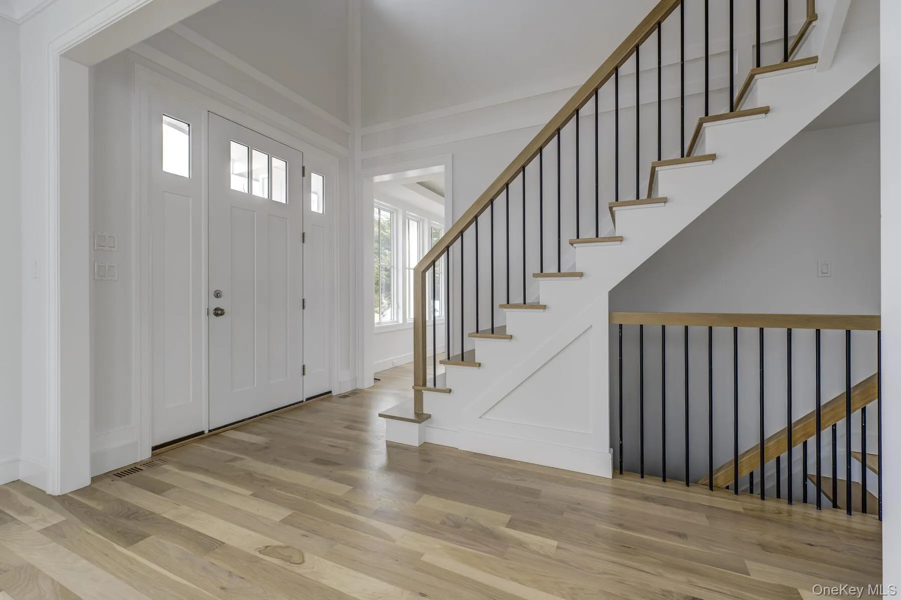 Entrance foyer with stairway and wood finished floors Entrance foyer with stairway and wood finished floors