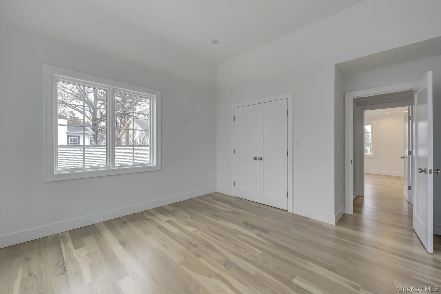 Unfurnished bedroom featuring light wood-style floors, baseboards, and a closet Unfurnished bedroom featuring light wood-style floors, baseboards, and a closet