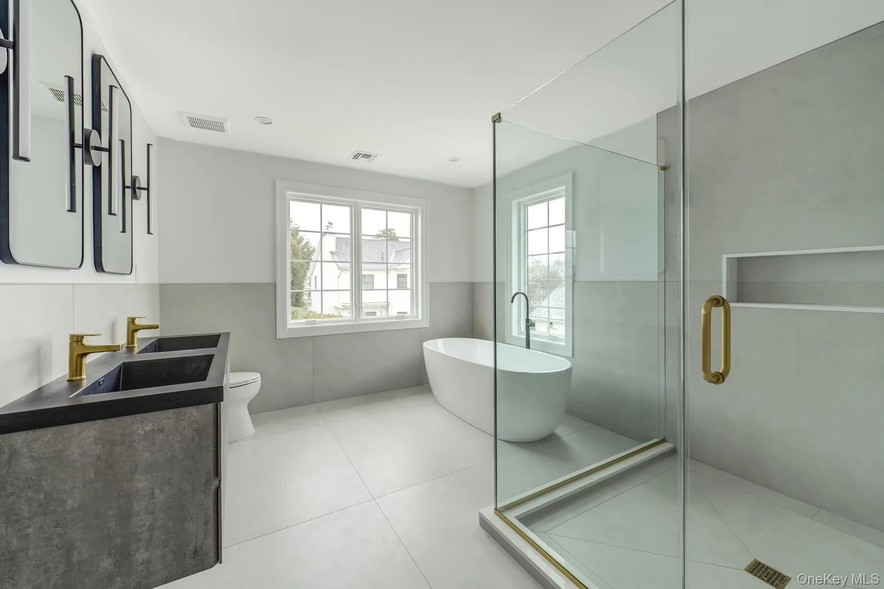 Full bath featuring a freestanding tub, tile patterned flooring, vanity, visible vents, and a shower stall Full bath featuring a freestanding tub, tile patterned flooring, vanity, visible vents, and a shower stall