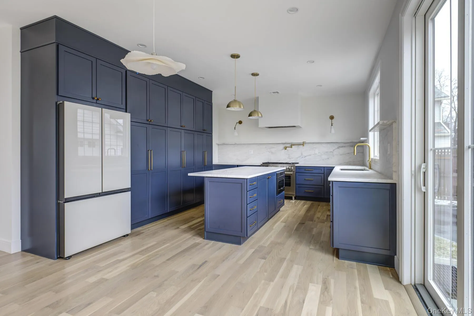 Kitchen with refrigerator, light countertops, a sink, and blue cabinetry Kitchen with refrigerator, light countertops, a sink, and blue cabinetry